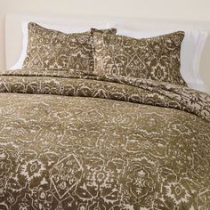 a bed covered in brown and white comforters