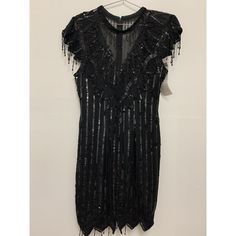 This Laurence Kazar Dress Is A Stunning Vintage Piece That Is Perfect For Any Occasion. The Dress Is Made Of 100% Silk And Has A Rayon Lining For Added Comfort. It Features Short Sleeves, A Zip Closure, And A Fringe Hem With Beautiful Beaded Accents. This Dress Is Available In Size M And Is Black In Color. It Is A Great Choice For A Wedding, Party, Cocktail, Workwear, Or Casual Event. The Style Of The Dress Is An Embellished Dress With Accents Of Fringe And Beaded Details. It Is A Regular Size T Black V-neck Flapper Dress For Evening, Embellished Fitted V-neck Flapper Dress, Embellished Sequin Knee-length Dress For Cocktail, Elegant Fitted Flapper Dress For Festive Occasions, Elegant Festive Flapper Dress For Evening, Elegant Festive Flapper Evening Dress, Festive Embellished Evening Flapper Dress, Elegant V-neck Flapper Dress For Night Out, Sequined Short Sleeve Evening Dress For Night Out