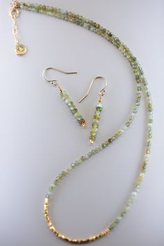 Add a touch of elegance to any outfit with the Root Green Garnet Gold Earrings. These dainty earrings feature solid natural stones with bright gold accents for a chic and refined look. Whether it's a casual day out or a special occasion, these earrings are the perfect accessory. Gold Gemstone Bead Drop Earrings, Gold Drop Earrings With Gemstone Beads, Elegant Faceted Earrings For May Birthstone, Elegant Green Gemstone Beads Jewelry, Elegant Gold Linear Earrings With Natural Stones, Elegant Gemstone Beads Earrings For Gift, Elegant Green Linear Earrings As Gift, Elegant Handmade Green Linear Earrings, Green Gemstone Bead Drop Earrings