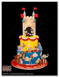 the cake is decorated with cartoon characters and castle like decorations on it's sides