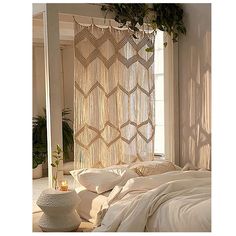 a white bed sitting under a window next to a potted plant