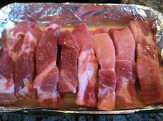 raw meat sitting on top of tin foil in a baking pan, ready to be cooked