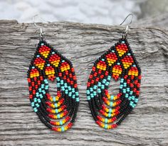 These stunning hand-beaded earrings draw inspiration from traditional Native American beadwork, blending bold geometric patterns with a modern twist. Each earring is meticulously crafted with high-quality glass seed beads, creating intricate designs that celebrate the beauty of indigenous artistry. The earrings feature a harmonious blend of vibrant colors often found in Native beadwork. Colors may appear slightly different in person due to variations in computer monitors. Traditional Red Beaded Earrings With Colorful Beads, Red Beaded Earrings With Colorful Beads For Festivals, Traditional Red Handwoven Beaded Earrings, Multicolor Traditional Beaded Earrings, Traditional Black Beaded Earrings, Traditional Red Beaded Earrings With Large Beads, Native American Beaded Earrings, Native Beadwork, Native American Beadwork