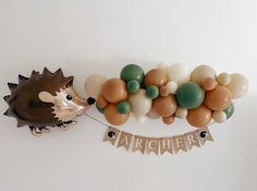 a hedgehog balloon and banner on a white wall