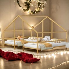 a wooden bed frame in a room with christmas lights on the floor and decorations around it