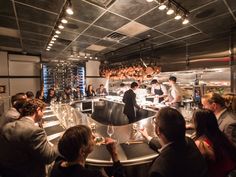 a group of people sitting around a bar