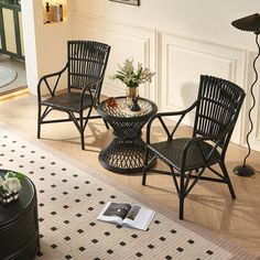 three chairs and a table in a living room with a book on the coffee table