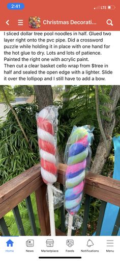 two lollipops wrapped in plastic sitting on top of a wooden deck next to a tree