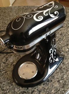 an old fashioned black and white mixer on a granite counter top