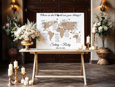 a table with candles, flowers and a world map on it in front of a wooden door