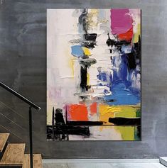 an abstract painting hangs on the wall next to some stairs