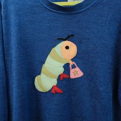 a blue shirt with a very cute caterpillar on it