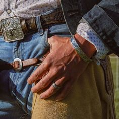 a close up of a person's hand on the back of a cowboy belt