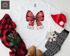 Christmas Coquette Bow Shirt, Christmas Santa Bow Shirt, Santa Claus Bow Shirt, Christmas Lights Shirt, Christmas Mom Gift Shirt, Xmas Holiday Shirt Welcome to MamaBearApparell! I am a professional designer and a Mama of twins. As a professional designer, I am delighted to offer you designed t-shirts that your entire family will love and cherish, making your special moments even more beautiful. We are working to provide you with high-quality soft t-shirts and sweatshirts with trendy designs. We prioritize quality materials and stunning designs to offer you the best service possible. Our handmade items will be the perfect choice for your celebrations, vacations, graduations, or birthday & wedding parties and holidays (such as Christmas, Thanksgiving ..)  Discount available on bulk orders! F Red Christmas Shirt For Holiday, Red Holiday Shirt For Gift, Red Holiday Shirt Gift, Holiday Red Shirt As Gift, Red Christmas Top For Gift, Red Christmas Tops As Gift, Red Christmas Top As Gift, Holiday Gift Red T-shirt, Red Festive Holiday T-shirt