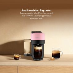 a coffee maker sitting on top of a counter next to two cups and a container