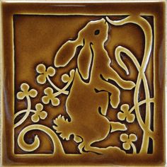 a tile with a dog and flowers in the center, on top of it is a brown