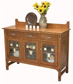 a wooden sideboard with glass doors and yellow flowers