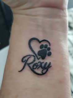 a dog paw and heart tattoo with the word roxy written on it's wrist