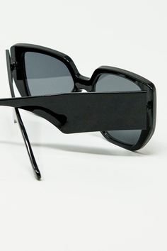 These black pin-up style sunglasses are a striking nod to 70’s Hollywood glamour, blending retro flair with a modern edge. The bold square shape, combined with a geometric cat-eye design, creates a captivating look reminiscent of vintage pin-up icons. The sharp, angular lines of the frame add a contemporary twist to this classic style, making them perfect for anyone looking to channel their inner starlet.  Crafted from 100% polycarbonate, these sunglasses offer both durability and lightweight comfort, ensuring they can be worn effortlessly throughout the day. The high-gloss black finish enhances their timeless appeal, making them a chic accessory for any occasion.  The model is wearing size U, designed to offer a universally flattering fit, making these sunglasses a versatile addition to a Retro Black Sunglasses For Evening, Retro Black Cat Eye Sunglasses With Tinted Lenses, Modern Rectangular Sunglasses For Party, Trendy Square Sunglasses For Party, Sleek Square Frame Sunglasses For Party, Chic Square Sunglasses For Party, Square Polarized Sunglasses For Parties, Black Square Sunglasses For Parties, Black Square Sunglasses For Party