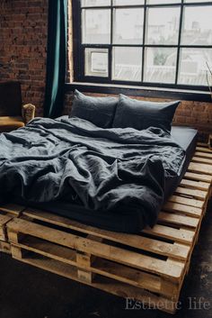 a bed made out of wooden pallets in front of a window