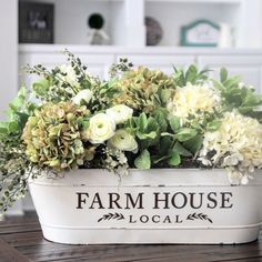 a planter filled with flowers on top of a wooden table