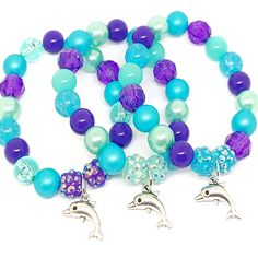 These adorable stretchy bracelets are the perfect favor for your little one's Under The Sea themed party! Each bracelet is made using an Tibetan silver charm, resin rhinestone beads and an assortment of 10mm acrylic beads in purple, blue and aqua strung with durable stretch floss cord. Each bracelet will arrive individually packaged in organza bags. Please message me if you have any questions, if you need a different amount of bracelets or if you would like your bracelets made in a different col Adjustable Purple Charm Bracelet For Birthday, Themed Personalized Blue Beaded Bracelets, Personalized Themed Blue Beaded Bracelets, Playful Blue Beaded Bracelets For Birthday, Playful Beaded Charm Bracelet For Birthday, Novelty Round Beads Bracelet For Birthday, Playful Assorted Jewelry For Birthday, Personalized Blue Charm Bracelet For Birthday, Playful Plastic Jewelry For Birthday