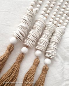 white beads and tassels are arranged in a row on top of each other