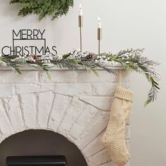 a fireplace decorated for christmas with stockings and candles