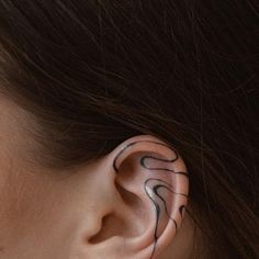 a woman's ear is decorated with black and white swirls on the side