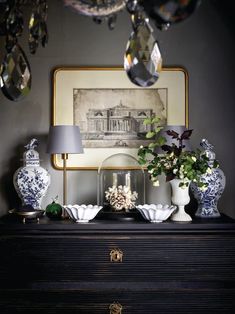 a black dresser topped with vases and lamps