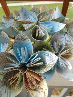 paper flowers made out of old books are displayed in front of a wooden window sill