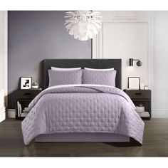 a bed with purple comforter and pillows