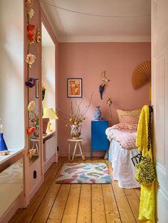 a bedroom with pink walls and wooden floors