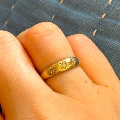 a person's hand with a gold ring on it