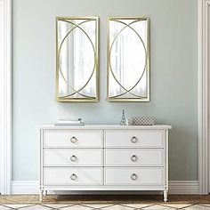 two mirrors on the wall above a white dresser