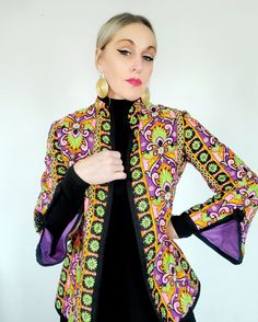 I LOVE this jacket!!  Groovy pattern, quilted but not too heavy, very comfortable.  Has the best sleeve details a purple lining . I think it is cotton blend, not sure.  It is in excellent condition and will fit a XS or a small. Fitted Multicolor Outerwear With Stand Collar, Retro Quilted Long Sleeve Outerwear, Quilted Retro Outerwear, Vintage Quilted Cotton Outerwear, Vintage Cotton Quilted Jacket For Fall, Vintage Purple Outerwear For Spring, Retro Purple Outerwear For Spring, Vintage Long Sleeve Cotton Quilted Jacket, Fitted Cotton Quilted Jacket For Fall