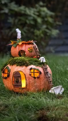 two pumpkin shaped houses sitting in the grass