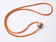 an orange cord with a silver ball on it and a string attached to the end