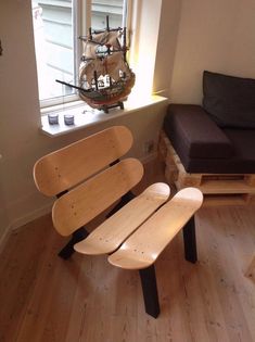 two wooden benches sitting next to each other on a hard wood floor in front of a window