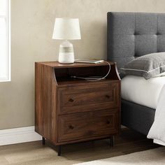 a bed with a night stand next to it and a lamp on the end table