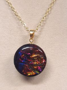 Beautiful dichro-ish film circle shape resin pendant necklace with  jewel tone hues of red, purple, gold, and saphire blue on 18k Gold plated 18" chain with lobster claw closure. Party Necklace With Large Round Pendant, Iridescent Necklace With Adjustable Chain For Gift, Iridescent Oval Pendant Necklace Gift, Iridescent Round Pendant Necklace For Gift, Iridescent Oval Pendant Necklace For Gifts, Iridescent Round Necklace For Gifts, Iridescent Round Necklace For Gift, Iridescent Round Glass Jewelry, Iridescent Glass Round Jewelry