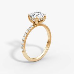 a yellow gold engagement ring with an oval cut diamond and side stones on the band