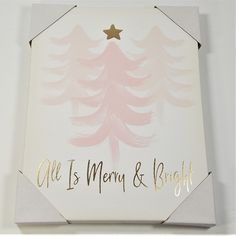 a white box with a pink and gold christmas tree on the front that says, all is merry & bright