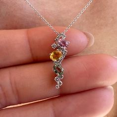 Materials: 18k White Gold Gemstone: Genuine Yellow Sapphire, Green Sapphire, Pink Sapphire, and Diamonds Total Multi-Color Sapphire Carat Weight: 3 sapphires totaling 0.85 ct. Total Diamond Carat Weight: 16 diamonds = 0.14 ct.  Pendant Diameter: 21mm x 6mm Diamond Clarity: SI 1-2 Diamond Color: G-H color Description: This listing is for the pendant only, the necklace is not included. These are genuine gemstones and diamonds, not lab grown An elegant pendant with pink sapphire, green sapphire, and yellow sapphire. Diamonds are elegantly placed around the sapphires to give that extra sparkle. A unique design for everyday wear or for a night out. This beautiful piece will not tarnish in the shower and will not irritate the skin. It will arrive in a jewelry box, with a jewelry bag for travelin Dazzling Multi-stone Sapphire Jewelry, Elegant Sapphire Multi-stone Necklace, Multicolor Diamond Necklaces For Anniversary, Sapphire Multi-stone Diamond Gemstones, Multi-stone Briolette Diamond Jewelry, Anniversary Sapphire Multi-stone Gemstones, Anniversary Multi-stone Sapphire Gemstones, Fine Jewelry Gemstone Pendant With Accent Stones, Briolette Multi-stone Diamond Jewelry