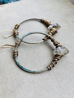 Large 2” brass hoops have been hammered and oxidized with a grunge dark turquoise patina and hand wrapped with dark herkimer diamonds & brass wire. Each hoop dangles 2.5” from 14k goldfill earwires. Handmade in NY Wire Spiral, Jewels Diy, Wire Earring, Wire Wrapped Jewelry Diy, Metalsmithing Jewelry, Boho Crystal, Wire Jewelry Designs, Earrings Hoops, Hippie Earrings