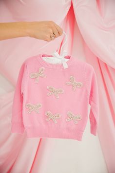 Wrap your little one in style with our MINI KIDS SILVER BOWS PINK SWEATER. This playful pink knit sweater features charming silver bows patches that will add a touch of whimsy to any outfit. And with the convenience of hand wash only, keeping it clean is a breeze. Perfect for the trendsetting toddler! This is a made-to-order item. All customized orders are currently shipping within 14 business days. To receive item quicker, expedited shipping is available at checkout. Light Grey Leggings, Bows Pink, Kids Dress Wear, Pink Knit Sweater, Kid Clothes, Pink Knit