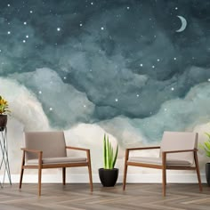 two chairs sitting next to each other in front of a wall with stars and clouds on it