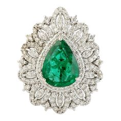 This exquisite ring features a stunning pear-shaped green emerald, surrounded by a sparkling array of diamonds, all set in 18k white gold. The emerald, with its deep green hue, is beautifully complemented by the brilliant diamonds, which enhance the ring's overall beauty and radiance. The band is designed to showcase the gemstones, with a sleek and elegant appearance that adds to the ring's sophisticated style. 18KT:7.187g, Diamond:0.83ct, Emerald:2.98ct, Size: US-7" Luxury Pear-shaped Emerald Anniversary Ring, Luxury Pear-shaped Emerald Ring For Women, Luxury Pear-shaped Diamond Emerald Ring, Emerald Ring With Diamonds, Auto Correct, Diamond Pendants Designs, Diamond Pendants, Zambian Emerald, I Love Jewelry