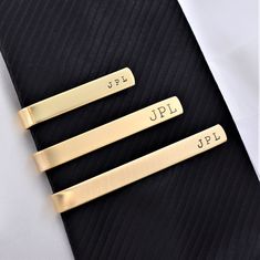 This artisan made tie bar/clip is fabricated from NuGold Brass sheet metal that mimics and is a cost-effective alternative to yellow gold. This handmade tie bar can be custom sized from 1.5 to 2.5 inches in length and can be personalized or left blank. In addition, we offer a choice of finishes to match your personal taste. They make a special, unique gift for a wedding, birthday, anniversary, or holiday. A tie bar is a functional keepsake for any guy who wears a suit and makes a great gift for Personalized Tie Clip, Gift For Groomsmen, Grandpa Birthday, Tie Bar Clip, Groomsmen Wedding, Personalized Tie, Gold Tie, Unique Ties, Fathers Day Presents