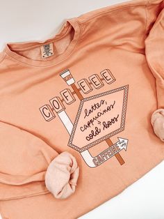 an orange shirt with the words coffee written on it and a bow in front of it